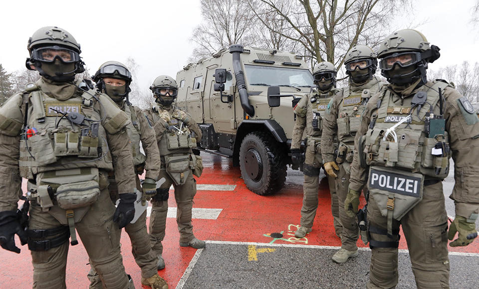 Spezialeinsatzkommando vor dem Anti-Terror-Fahrzeug 'Survivor R' 