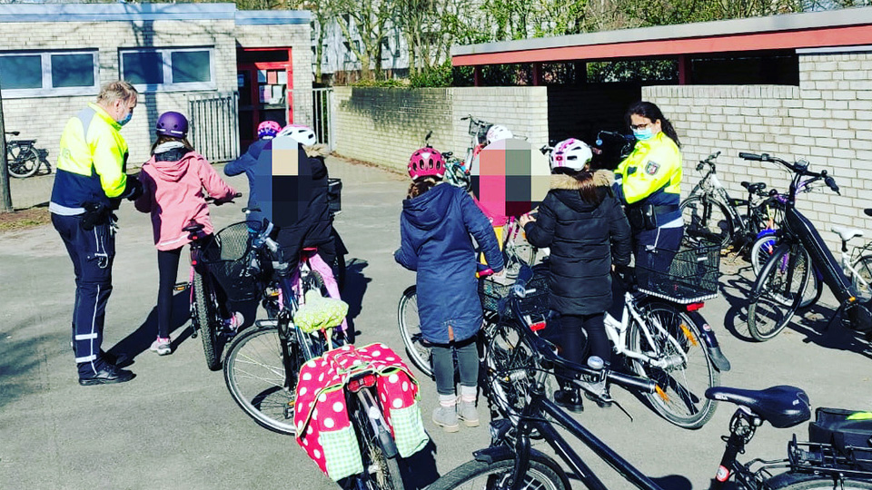 Polizisten mit Schülern beim Fahrradtraining