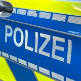 Schriftzug "Polizei" auf einem Streifenwagen