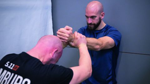 Two bodyguards train tactical intervention techniques in a training room