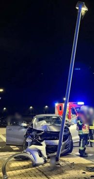 Auto steht vor einem Laternenmast. Die Front des Wagens ist kaputt.