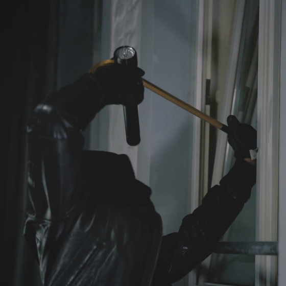 Einbrecher in der Nacht hebelt Fenster auf
